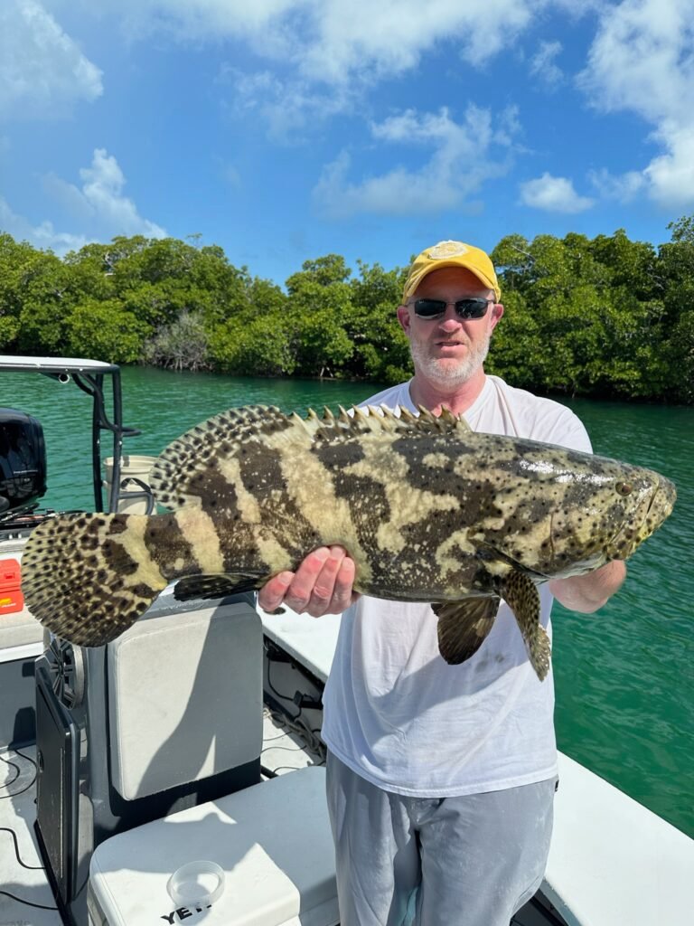 Angler holding a goliath grouper caught in Key West backcountry