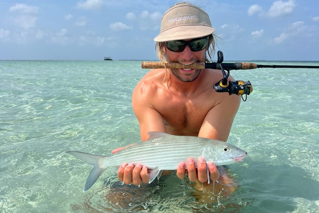 Capt Blake holding a bonefish in shallow clear water in Key West