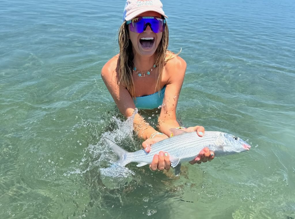Excited angler holding a bonefish in shallow Key West waters