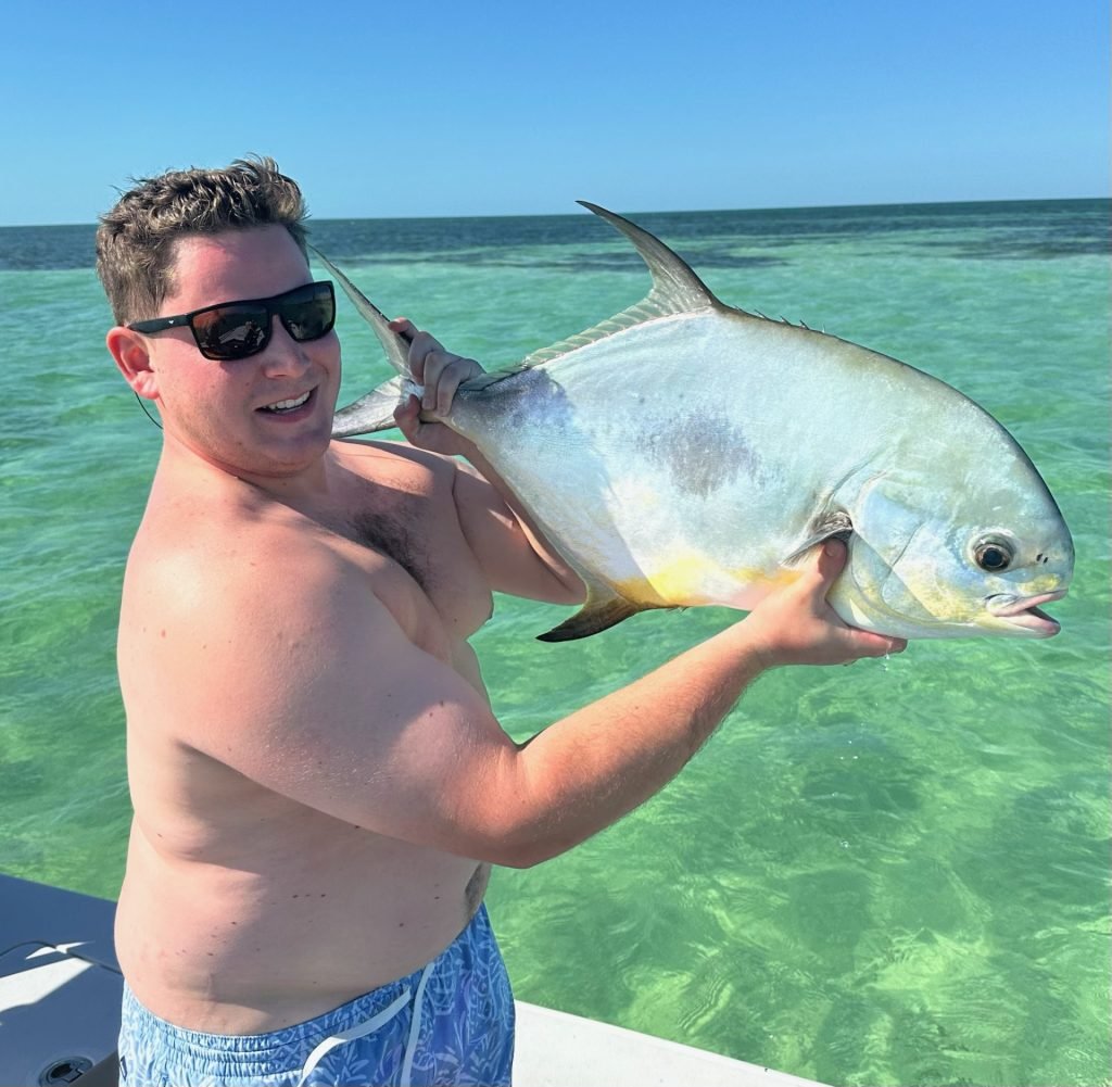 Tyler R holding a permit caught in the clear waters of Key West
